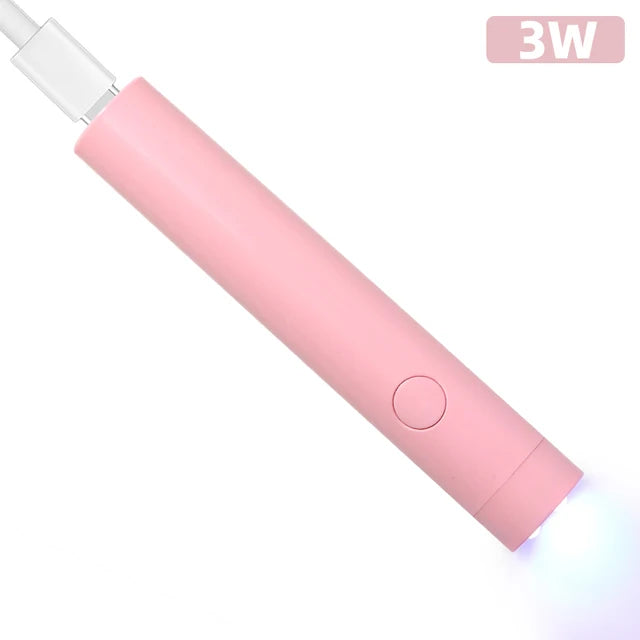 Pink compact nail lamp for travel with USB port and power button emitting blue light