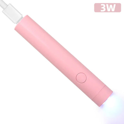 Pink compact nail lamp for travel with USB port and power button emitting blue light