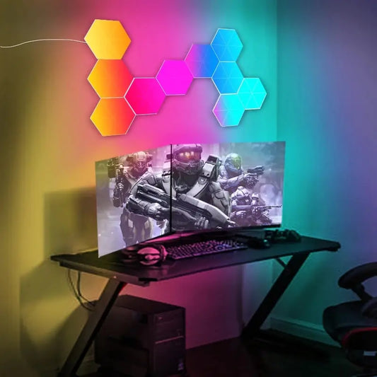 Colorful hexagon LED wall lights arranged above a gaming desk with triple monitors and a keyboard