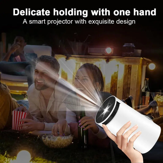 Hand holding Hy300 smart projector projecting light at outdoor movie night with friends
