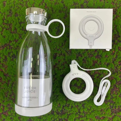 Portable juicer blender with clear glass bottle and white circular base with charging cable