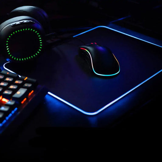 Symphony RGB desk mat glowing blue with a gaming mouse and illuminated keyboard in a dark setup